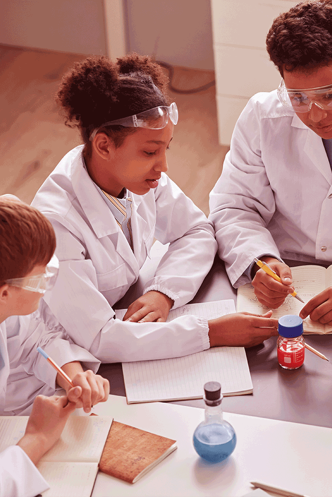 Teacher and students working with chemistry